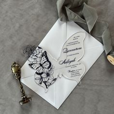 a white envelope with a butterfly design on it and a key to the wedding card