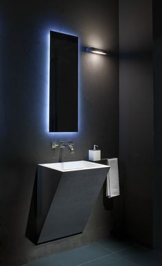 a bathroom with a sink, mirror and lights on the wall