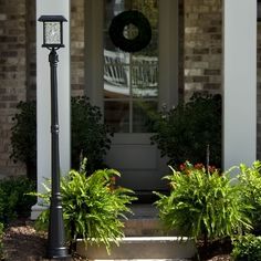 a front porch with plants and a lamp post