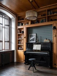 an old piano is sitting in front of a bookshelf