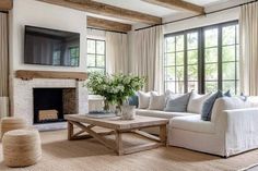 a living room filled with furniture and a flat screen tv mounted on the wall above a fire place