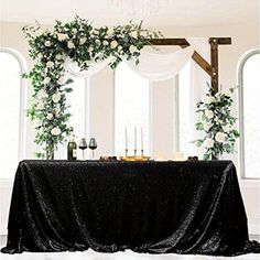 the table is covered with black sequins and greenery for an elegant look