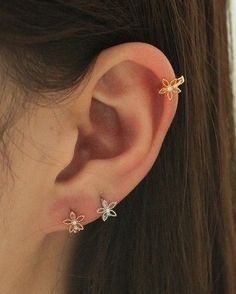 a close up of a person's ear with three small flowers on it