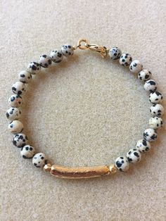 Dalmatian jasper gemstone bracelet with a boho, organic vibe. The 6mm dalmation  jasper stones are each unique with splotches of black on an off white background, similar to a dalmatian puppy.  An antique gold tube bead pairs with the gemstones. The bracelet closes with a lobster clasp. This bracelet is super cute by itself or stacked with other bracelets. Unique Crystal Bracelets, Gemstone Bracelet Ideas, Dalmatian Stone Bracelet, Jasper Dalmatian Stone, Lapis Lazuli Dalmation Jasper Bracelet, Dalmatian Jasper Jewelry, Dalmatian Jasper Bracelet, Dalmatian Jasper Necklace, Jasper Jewelry