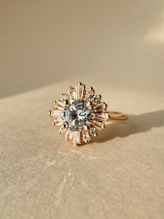 a diamond ring sitting on top of a white table next to a light colored wall