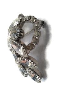 1950s Silver tone Rhodium plated brooch. Clear, prong set gems make this brooch shiny and statement making. The brooch depicts a bleeding heart 3D design. Gift for Her. DETAILS: ☼ Approximately 1 1/2 by 2 inches. ☼ Approximately 14.9 grams, total weight. ☼ ☼ ☼ ☼ ☼ ☼ ☼ ☼ ☼ ☼ ☼ ☼ ☼ ☼ ☼ ☼ ☼ ☼ ☼ ☼ ☼ PLEASE NOTE: ☼ Different items on SALE everyday! Check back often to take advantage of these bargains! ☼ FREE DOMESTIC SHIPPING on purchases of $35 or more. Combined shipping is still available to domest Vintage Rhinestone Brooches For Anniversary, Retro Silver Brooches For Anniversary, Silver Retro Brooches For Anniversary, Silver Costume Jewelry Pins For Formal Occasions, Retro Silver Brooch Pin, Silver Retro Brooch Pin, Vintage Silver Brooch Jewelry, Silver Brooch Pins For Costume Jewelry, Retro Silver Brooches For Formal Occasions