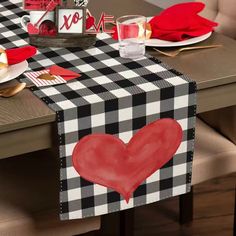 a black and white checkered table runner with a red heart on the center piece