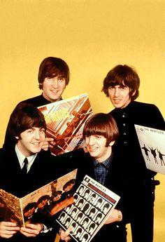 the beatles posing for a photo with their album covers