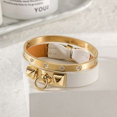 Sku: NSB1400GC-NSB1550STZD Details: Sleek and simple, this bracelet in leather with 14K gold plated. It is a statement-maker on its own or layered with other pieces. A great edition to an urban look or an informal outfit. This 14K gold/rose gold PVD bangle embellished with clear five of our best CZ stones. Arranged in an attractive and pleasing pattern, they catch the light from every angle. Our beautiful pieces are made of a metal that is hypo-allergenic which is great for those with sensitive Sleek Chic, Jewelry Candles, Chic Leather, Urban Looks, Cartier Love Bracelet, Cz Stone, Jewelry Designs, Gold Rose, Active Wear For Women