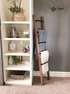 a ladder leaning up against a wall next to a book shelf with towels on it