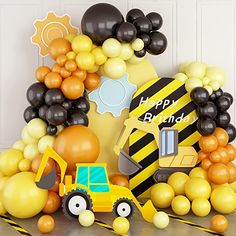 a construction themed birthday party with balloon decorations and balloons on the floor, including an excavator truck