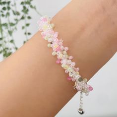 a woman's arm with a bracelet made out of flowers and beads on it