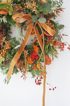 a christmas wreath with oranges, berries and pine cones