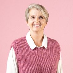 an older woman wearing a pink sweater vest