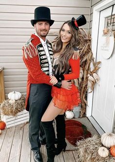 a man and woman dressed up in costumes posing for a photo on the front porch