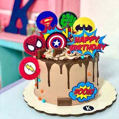 the birthday cake is decorated with superhero symbols