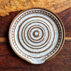 a brown and white plate sitting on top of a wooden table