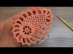 the crochet doily is being held in someone's hand