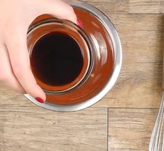 a person is holding a saucer on a wooden table