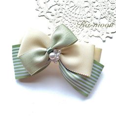 a green and white bow with pearls on it