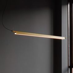 a light hanging from the side of a wall next to a window in a room