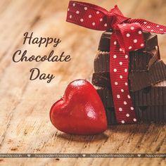 there is a heart and some pieces of chocolate on the table with words happy chocolate day