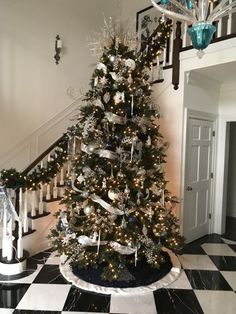 a decorated christmas tree in the middle of a room with black and white checkered flooring