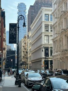 cars are parked on the street in front of tall buildings