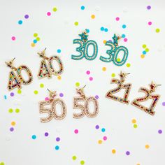 five pairs of earrings with the number 50 and fifty on them, all decorated in different colors