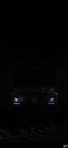 a black car in the dark with its headlights on