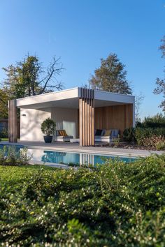 a house with a swimming pool in front of it and trees around the back yard