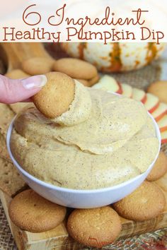 healthy pumpkin cheesecake dip in a white bowl with crackers on the side and an orange pumpkin in the background