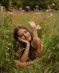 a beautiful young woman laying in the grass