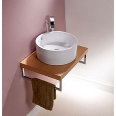 a white sink sitting on top of a wooden shelf