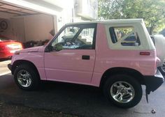 a pink car parked in front of a house