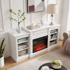 a living room with white furniture and a fireplace