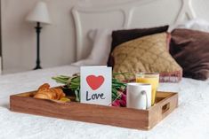 a tray filled with breakfast items on top of a bed