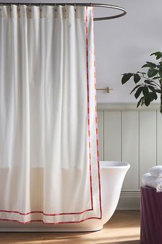 a white bath tub sitting next to a shower curtain