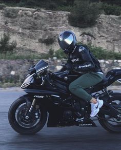 a man riding on the back of a black motorcycle