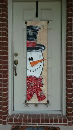 a door with a snowman painted on it and a red scarf hanging from the front