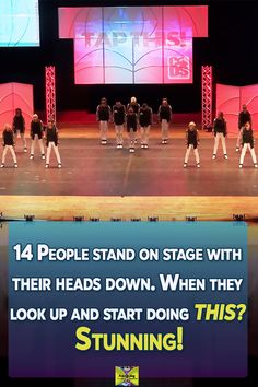 there are many people standing on stage with their heads down, when they look up and start doing this