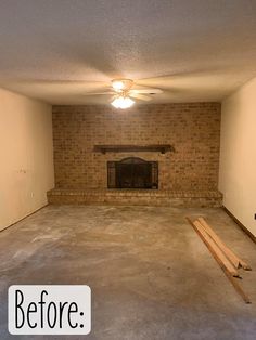 an empty living room with brick fireplace and unfinished floor