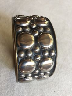 "Boho Metal Bangle Bracelet, Silver Bubbles of varying sizes with black undertones. Inside is a bronze gold color. Measures about 9.25\" around and 1.5\" wide. Inside is a tag that says CI, No. 325, and if anyone knows what that means please tell me! Also, please take a look at my storefront at: https://www.etsy.com/shop/FabFinds42?ref=seller-platform-mcnav I have a wide selection of one-of-a-kind items, from clothing and toys to home decor and gift items, and I add new things almost every day!" Adjustable Unique Style Nickel Free Bangle, Unique Metal Bracelets, Unique Metal Round Bracelets, Handmade Silver Cuff Bracelet With Beads, Vintage Silver Wristband As Gift, Bohemian Round Bracelets For Collectors, Unique Adjustable Round Cuff Bracelet, Vintage Adjustable Beaded Bangle Bracelets, Handmade Silver Cuff Bracelet With Round Beads