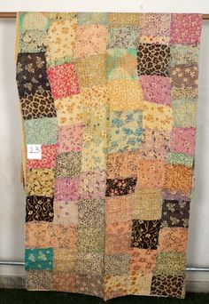 an old patchwork quilt hanging on the wall