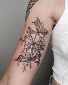 a woman's arm with a flower tattoo on it