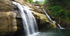 a large waterfall in the middle of a forest