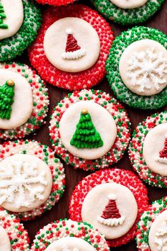 christmas cookies decorated with icing and sprinkles are arranged on a table