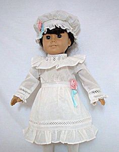 the doll is wearing a white dress and hat