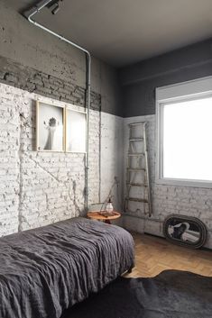 a bedroom with white brick walls and wooden floors