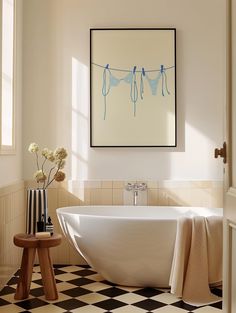 a white bath tub sitting next to a black and white checkered floor